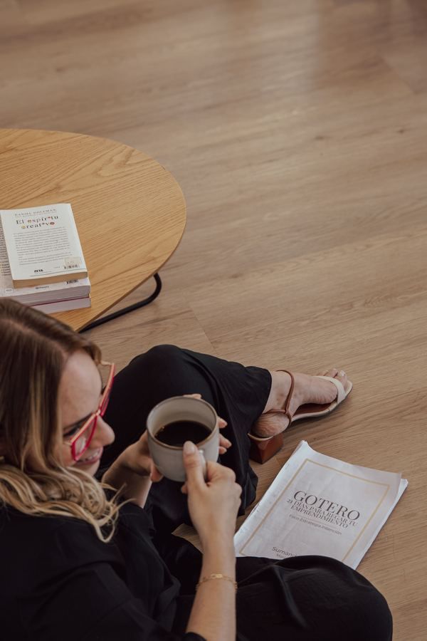 María leyendo el cuaderno de Gotero con un café